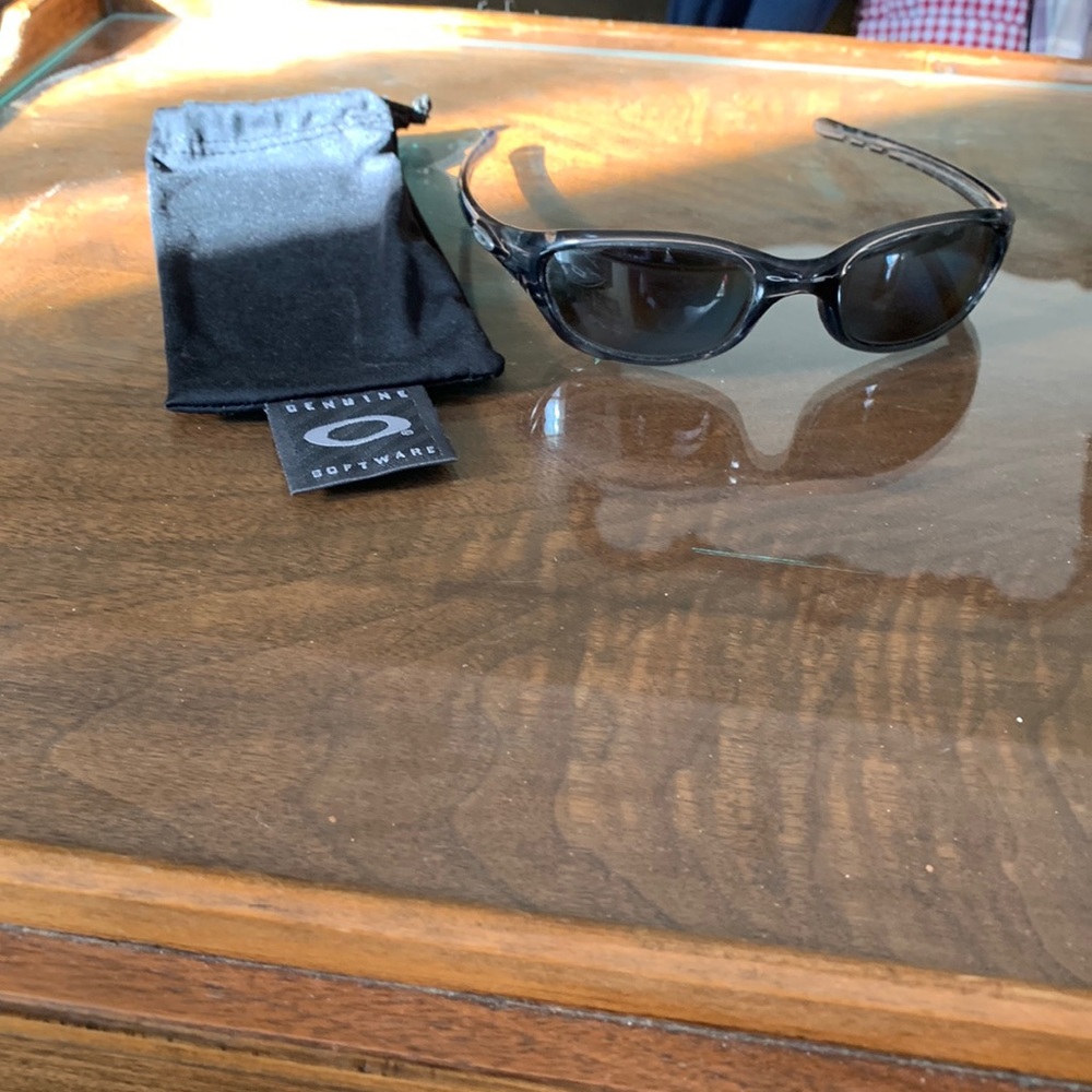 Oakley black sunglasses. Minor scratches on lens. Comes with original  bag.